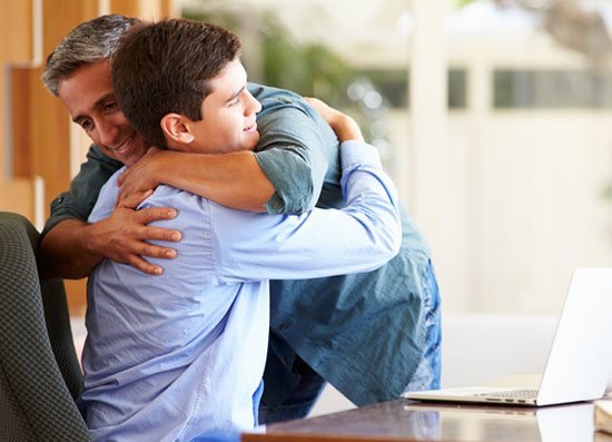 Father And Teenage Son Having A Hug